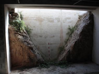 Imatge del fossat romà seccionat al seu pas pel carrer de la Pau, des del soterrani d'un edifici